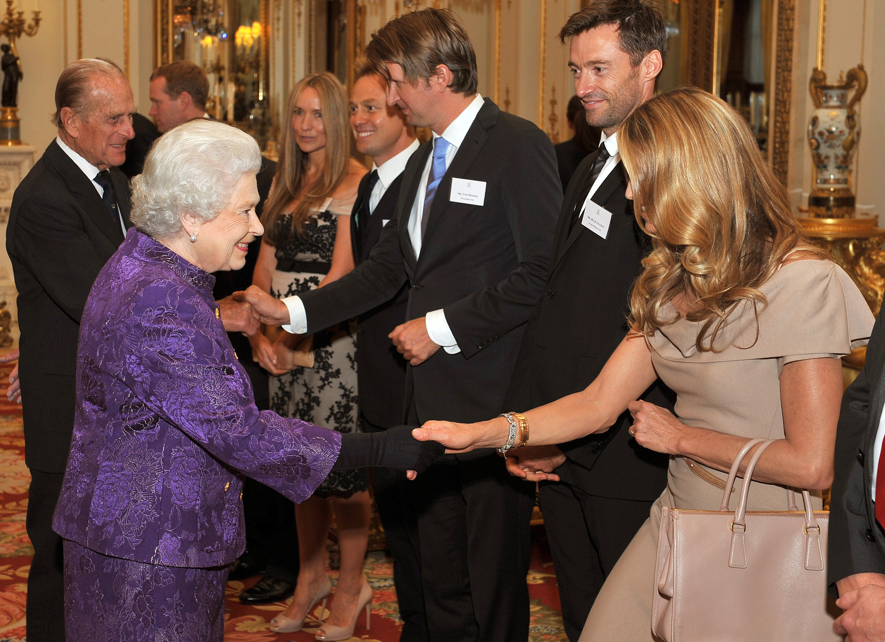 Queen Elizabeth II shakes hands with model Elle Macpherson in the white drawing room before a Royal reception for members of the Australian community living in the UK at Buckingham Palace on October 13, 20in London, England.